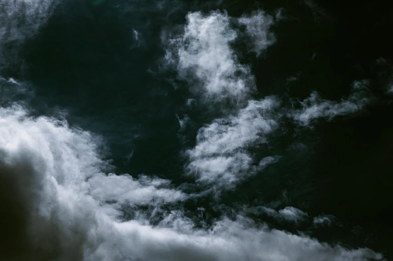 some very beautiful clouds with a plane flying overhead