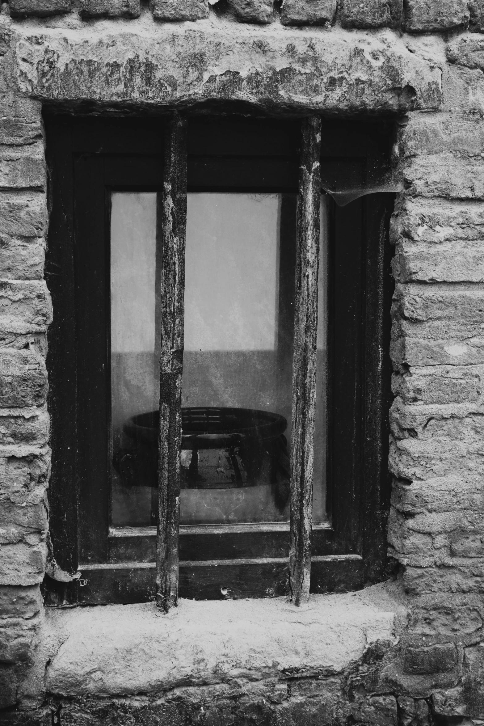 a window in a stone wall, with bars on the sides