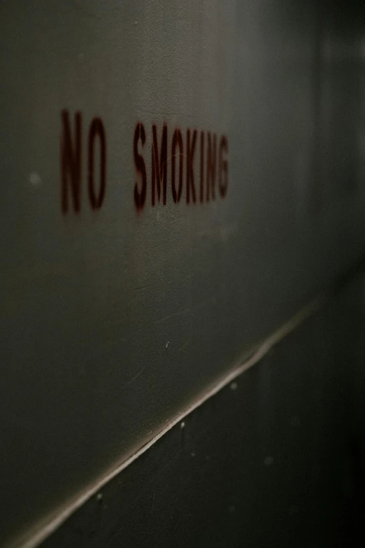 a sign that says no smoking underneath a light