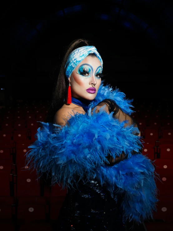 a woman dressed as a peacock wearing blue feathers