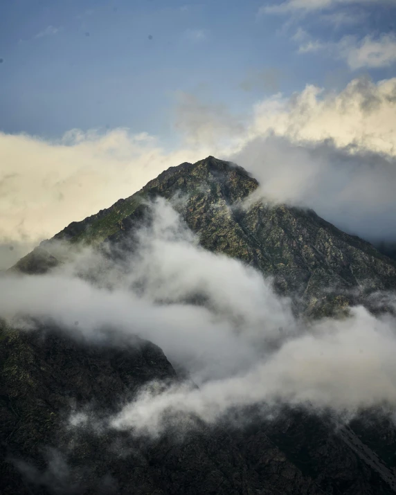 a large hill with very small clouds hanging over it