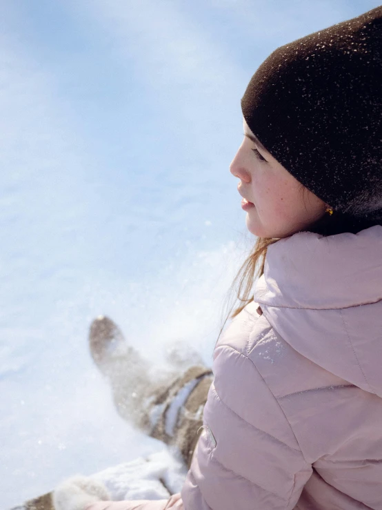 a woman wearing a winter jacket riding a snowboard