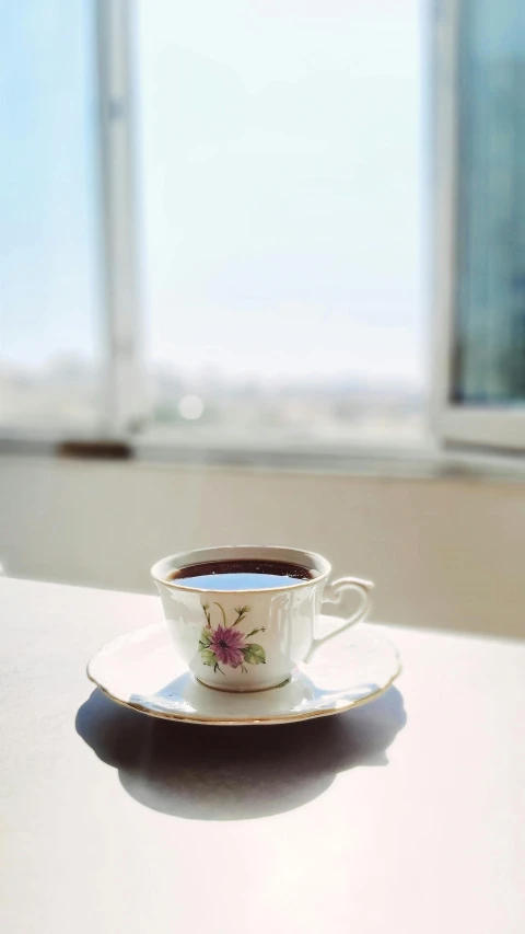 a white cup and saucer sitting on a table