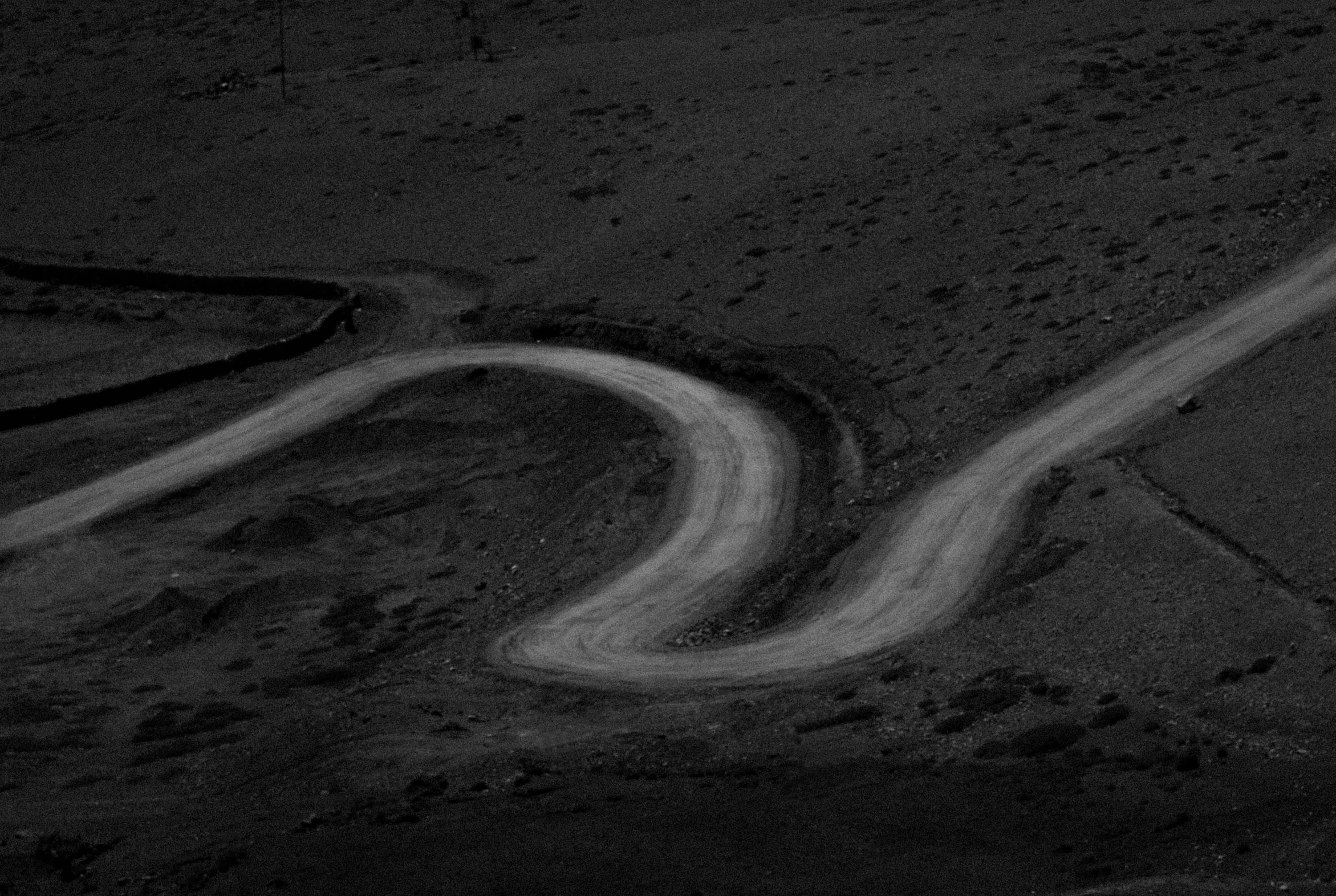 a road going down hill and a curve in the road