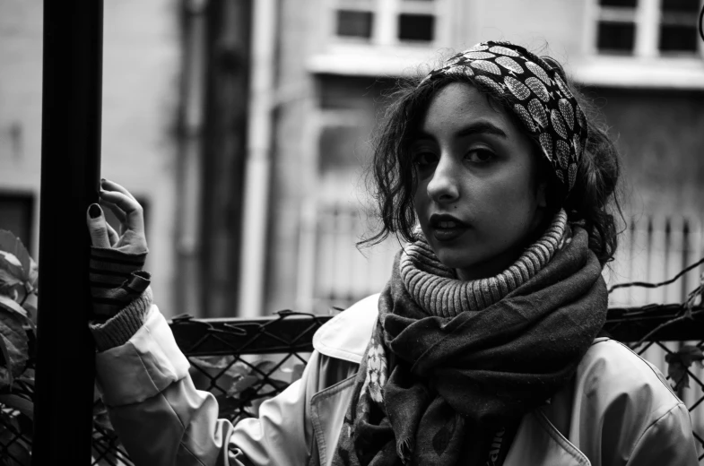 a woman is standing in front of a fence holding her hand out