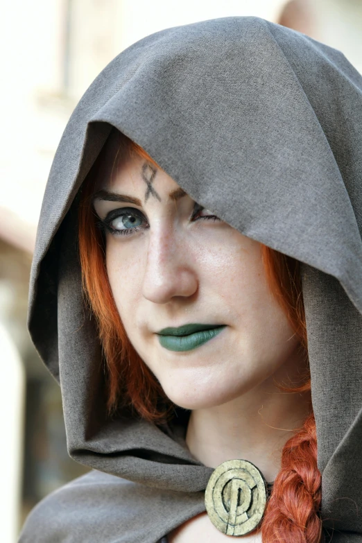 a woman with red hair wears a large collar brooch