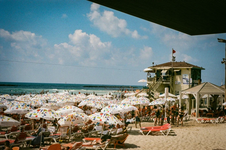 a beach filled with lots of people next to the ocean