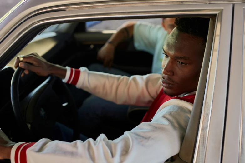 a man sits in his car with a steering wheel