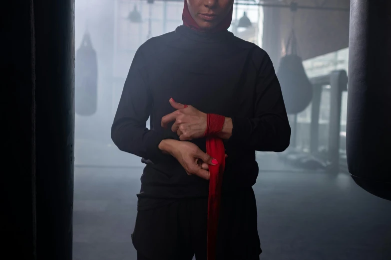 an older man in black boxing gear with a red rubber ring