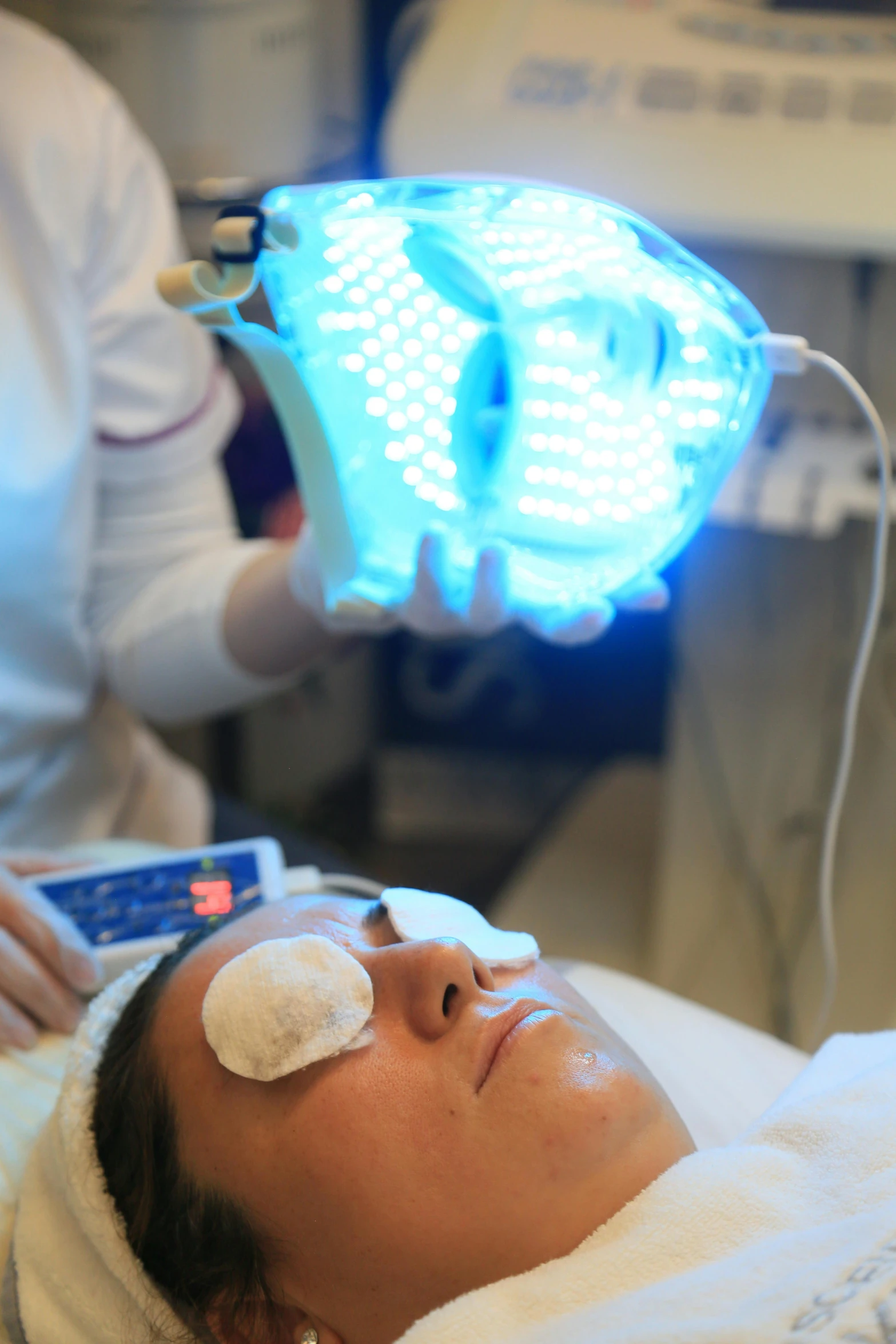 an older man laying in a bed wearing a light up device