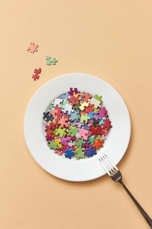 the fork is next to a plate full of multicolored pieces