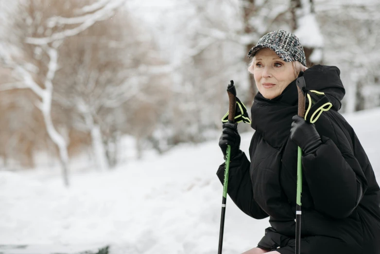 woman sitting on bench holding ski poles in snowy area