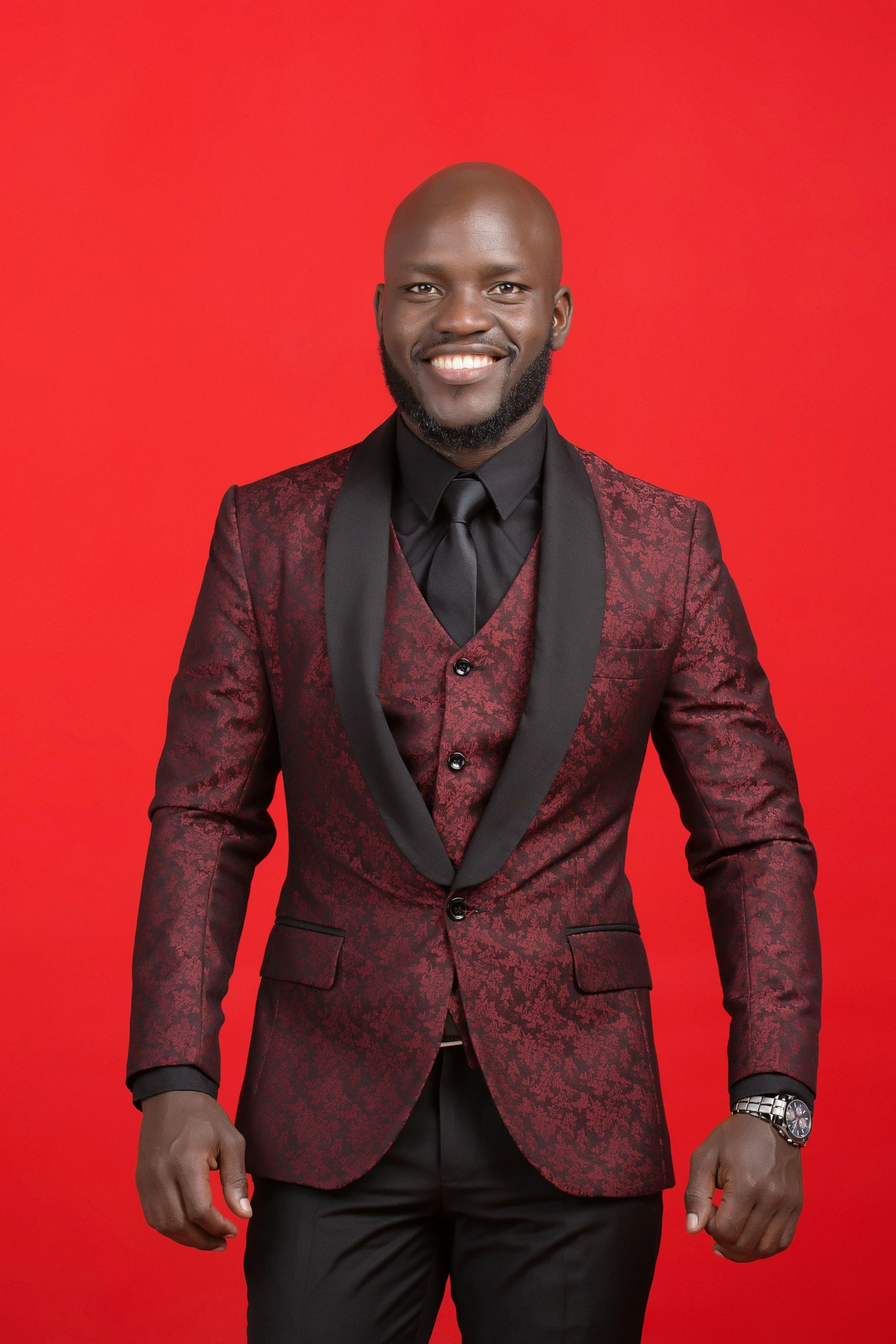 a black man with a maroon blazer and tie