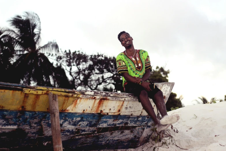 the man is sitting on the end of a old boat