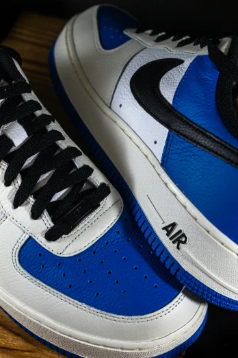 the blue and white air force sneakers are on a wooden surface