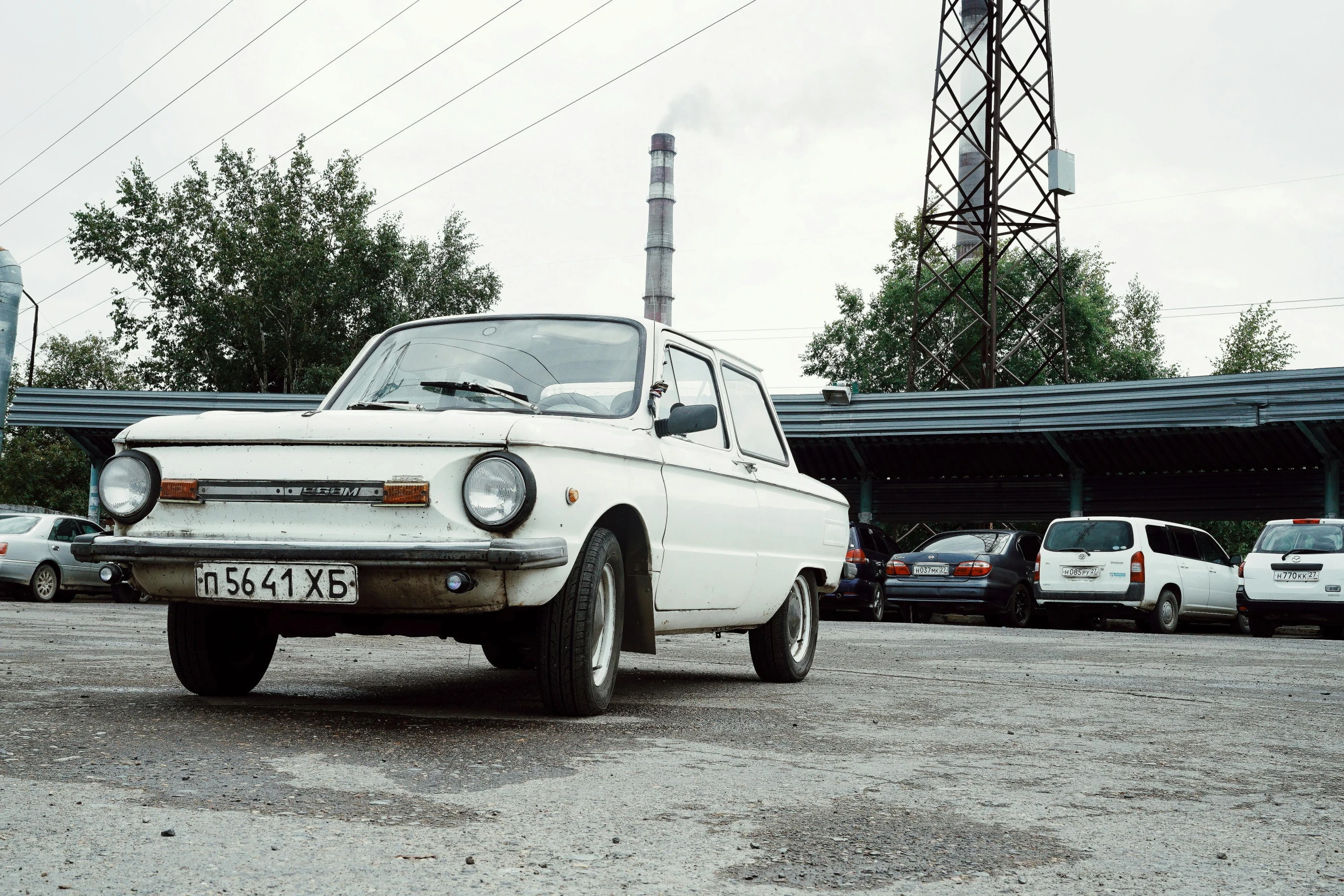 a white car that is parked outside in the dirt