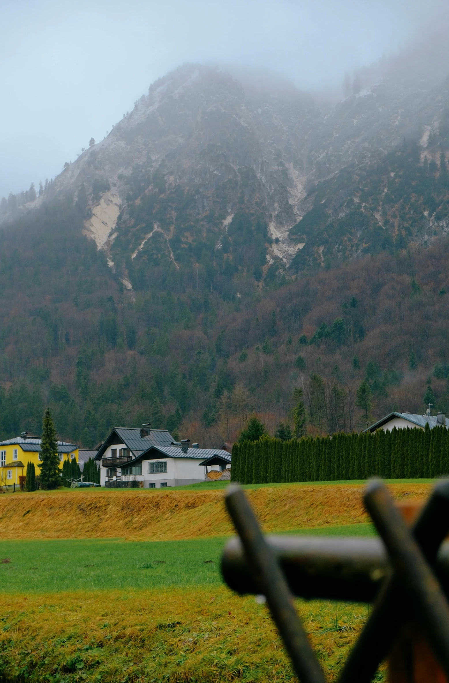 the mountain behind a bench is covered with clouds