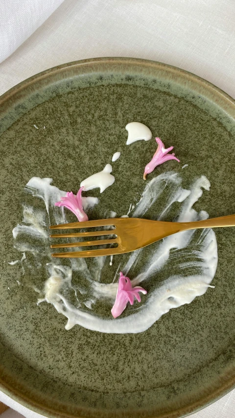 a plate with white and pink food and plastic forks