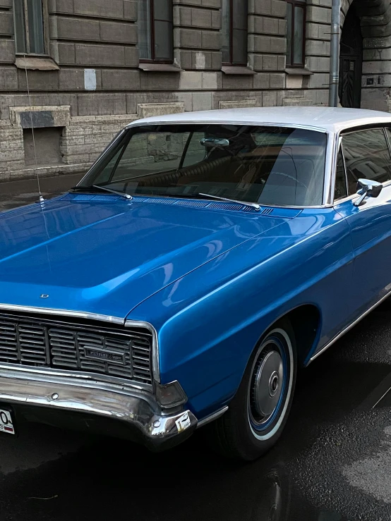 an old, blue car sits in a city parking lot