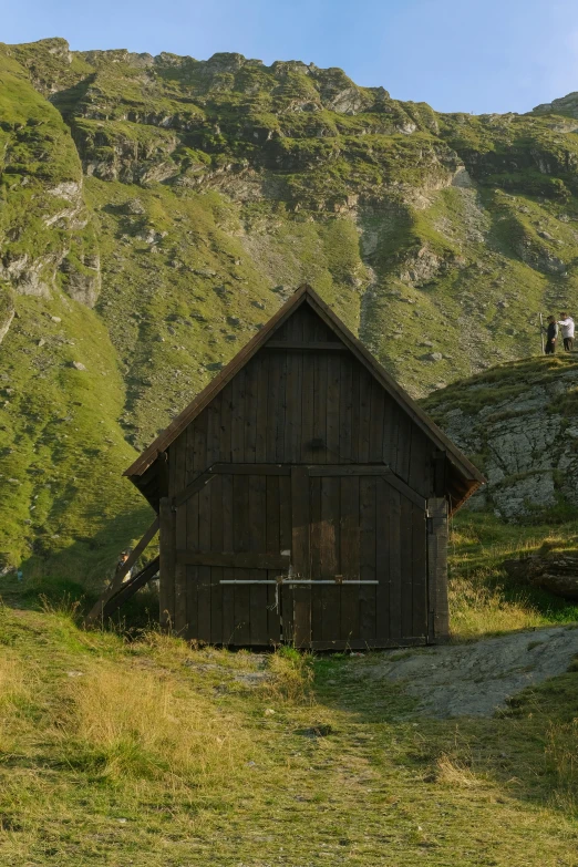this hut has a mountain in the back ground