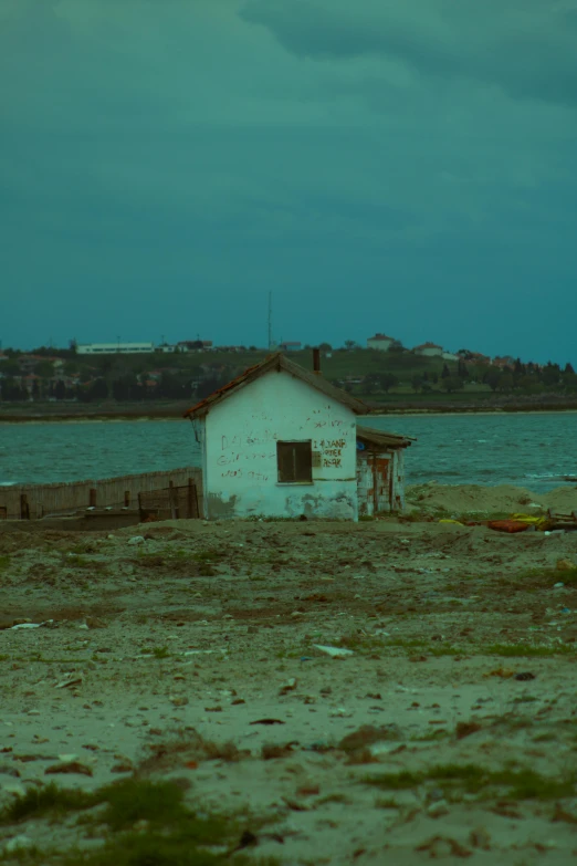 an old shack near the water is sitting out on the shore