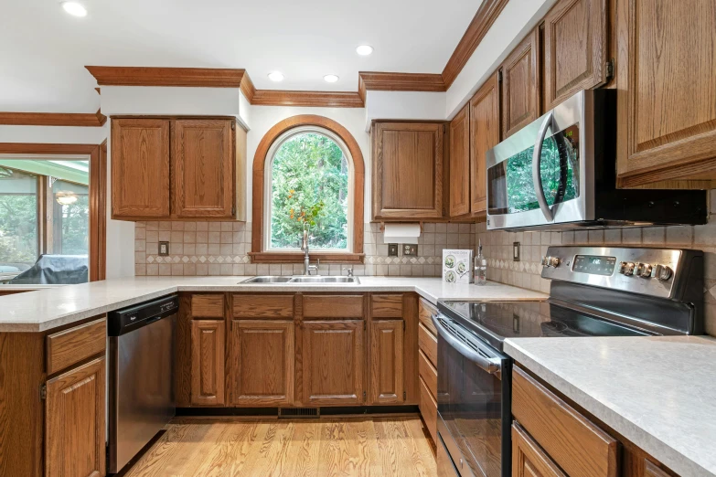 a kitchen with oak cabinets and marble counters