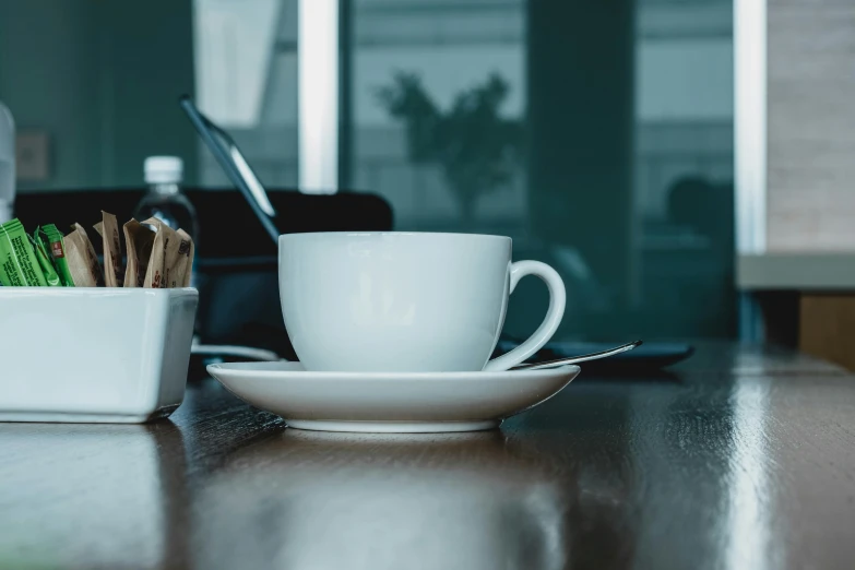 a coffee cup and saucer are next to a plate of cookies