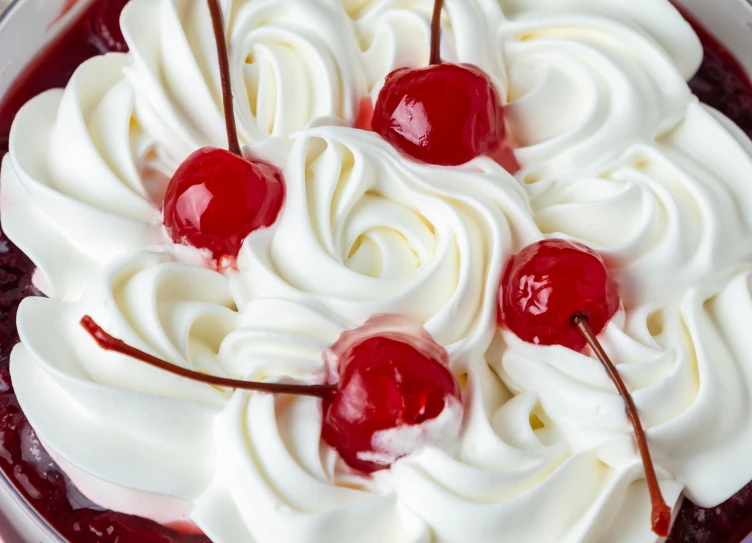 a white and red cake with cream and cherries