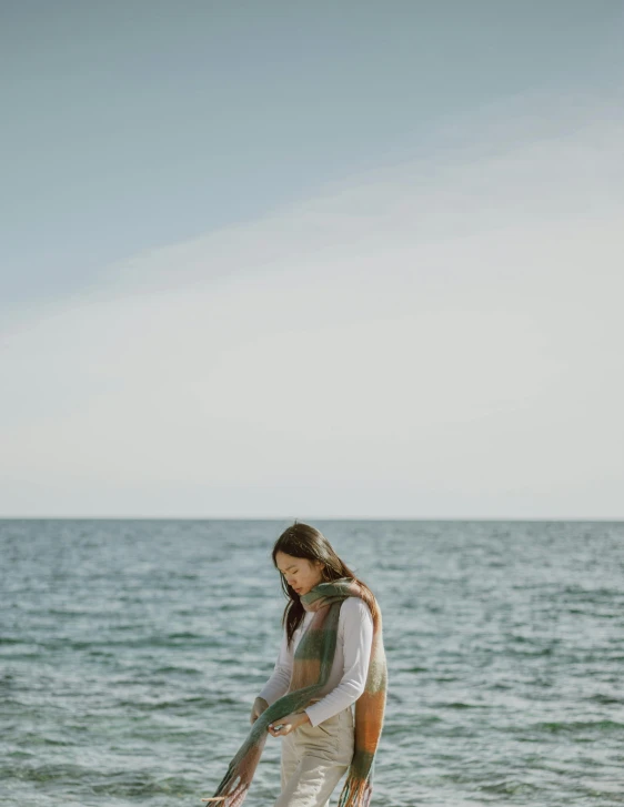 a girl stands in the water holding onto an umbrella