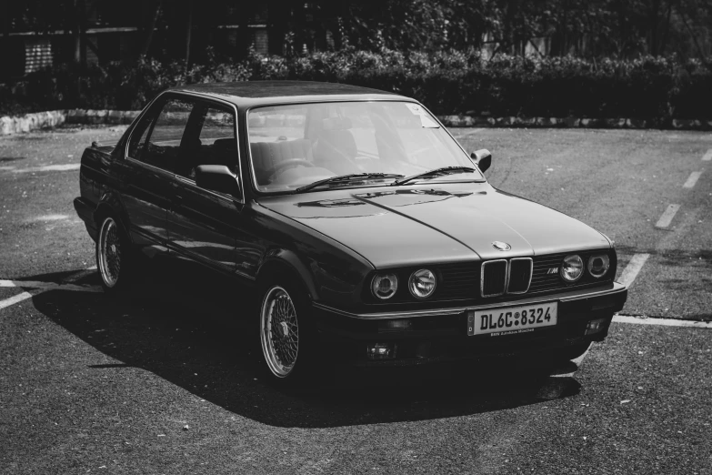 an old bmw is parked in a parking lot