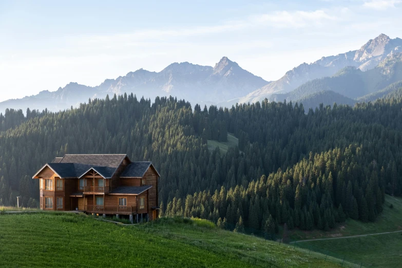 this is a cabin nestled on a green hillside