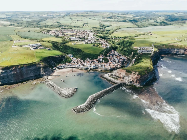 aerial view of town nestled on a cliff overlooking ocean