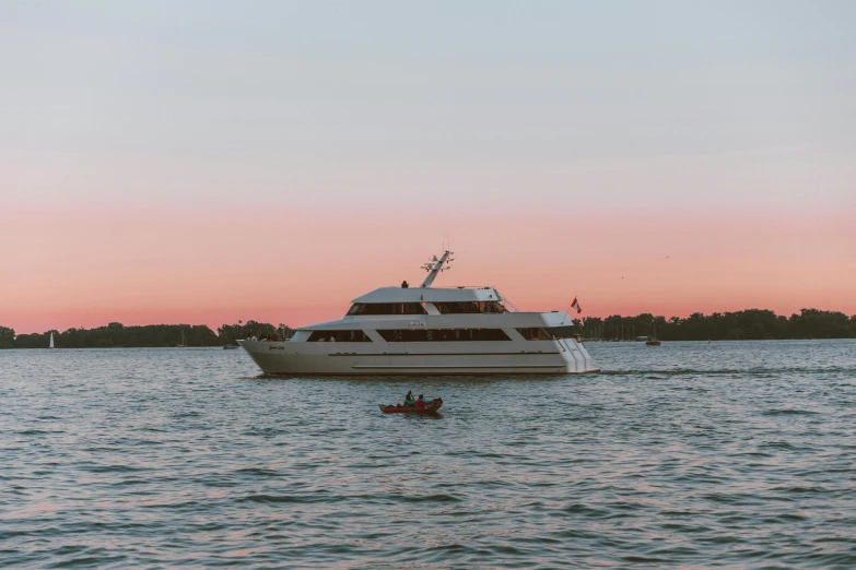 the boat is sailing on the water at sunset