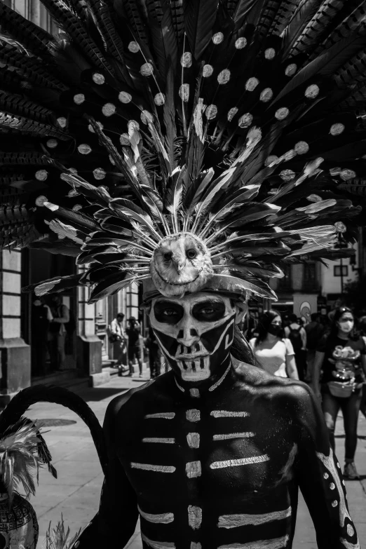 skeleton in day of the dead costume standing next to a crowd