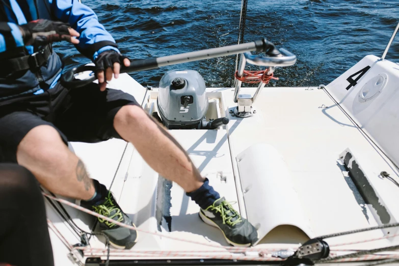 man sitting on boat while holding out his legs