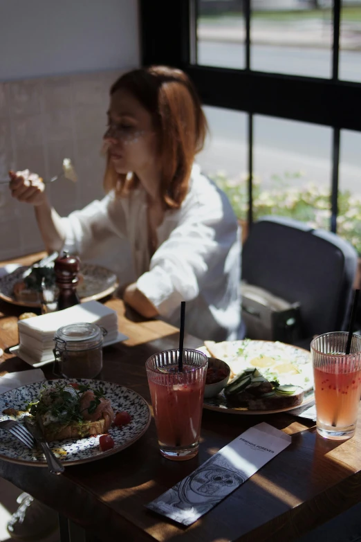 a woman sitting at a table with a plate of food