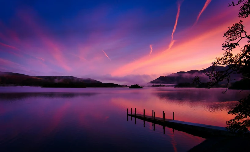 a beautiful colorful sky and clouds over a body of water