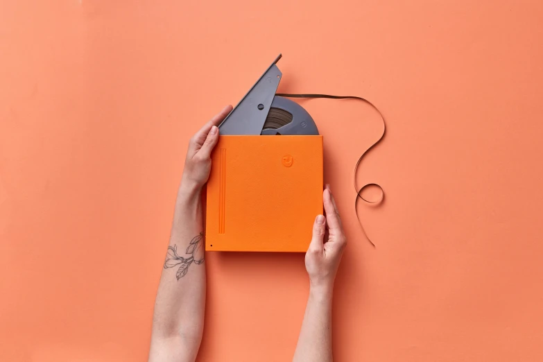 someone is  a paper origami clock out of an orange piece of paper