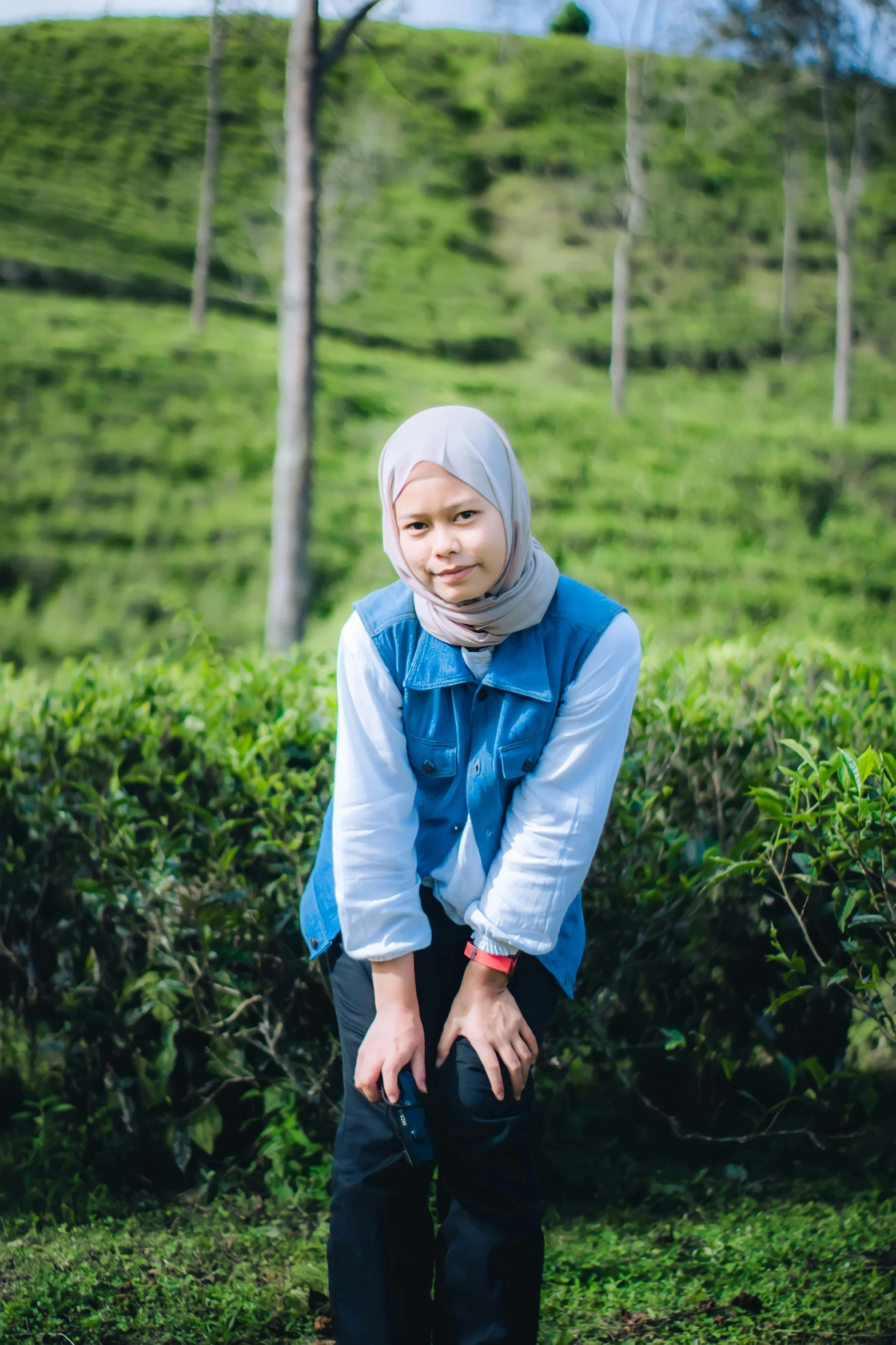 there is a woman in a dress posing in the middle of a tea plantation