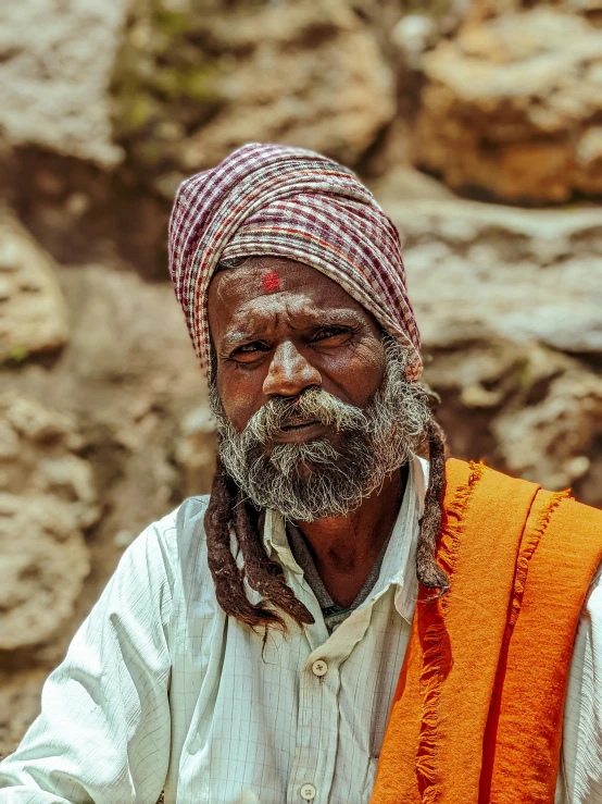 an old man is wearing a red scarf