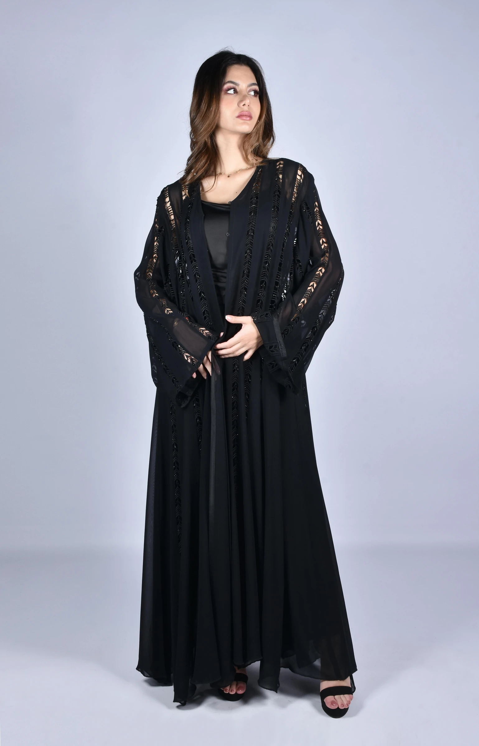 a woman in a black gown and cardigan