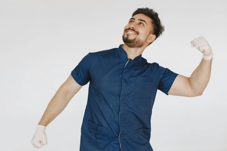 a man in an scrub suit has his fists raised