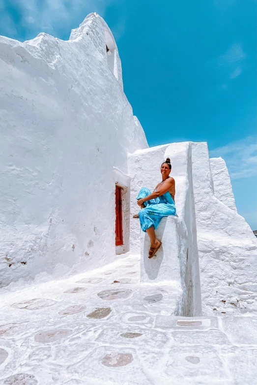 a person that is sitting down in front of some white houses