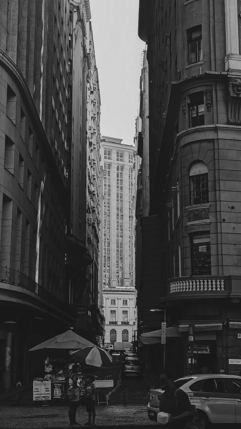 two people are standing in an urban area under a very large building