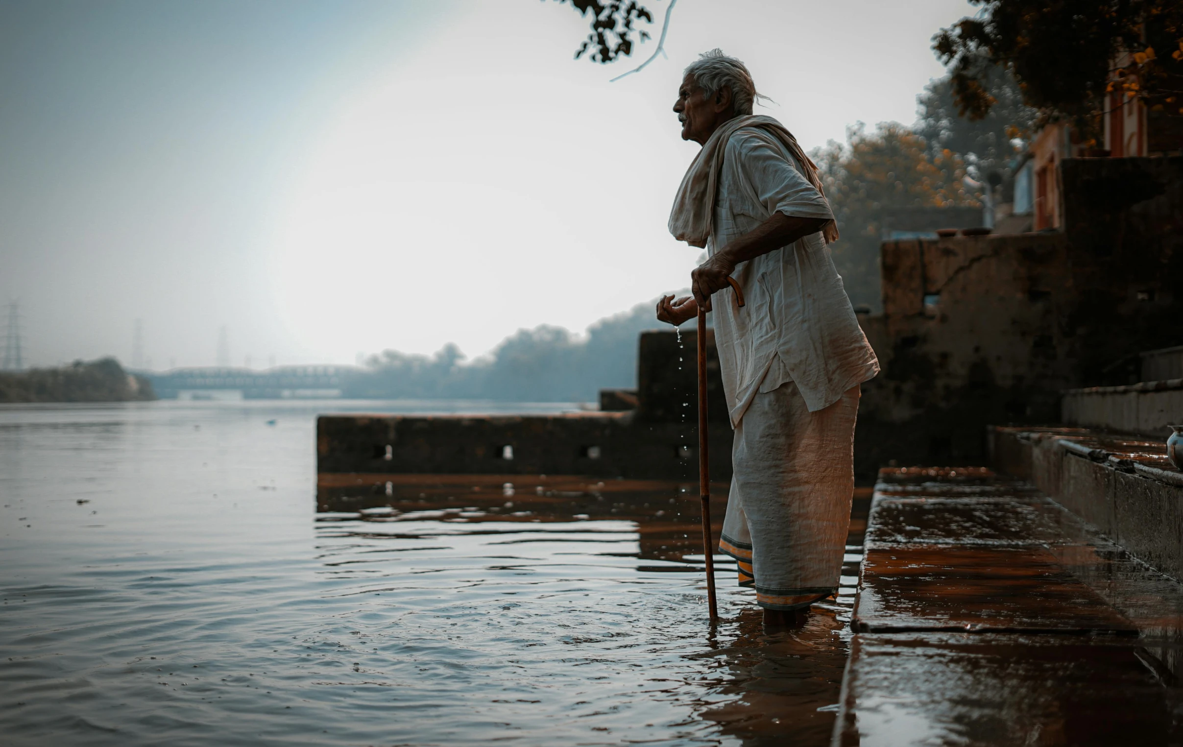 a man with an umbrella is standing on a dock in the rain