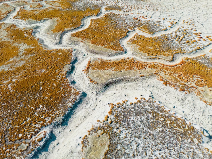 aerial view of a snowy desert with orange and blue colors