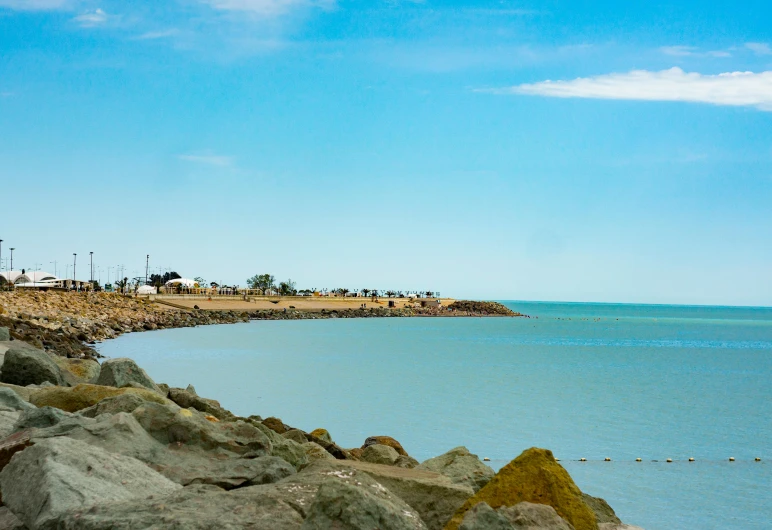 a large body of water next to rocks and some water