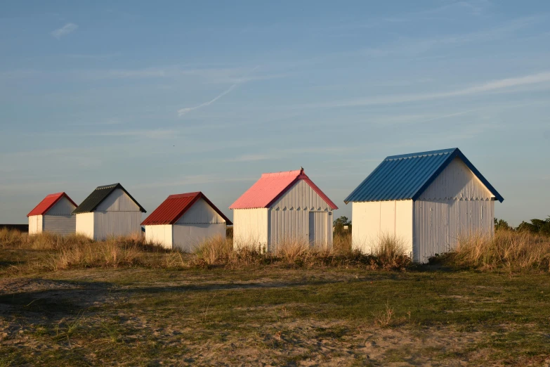 an image of row of small beach huts on the coast