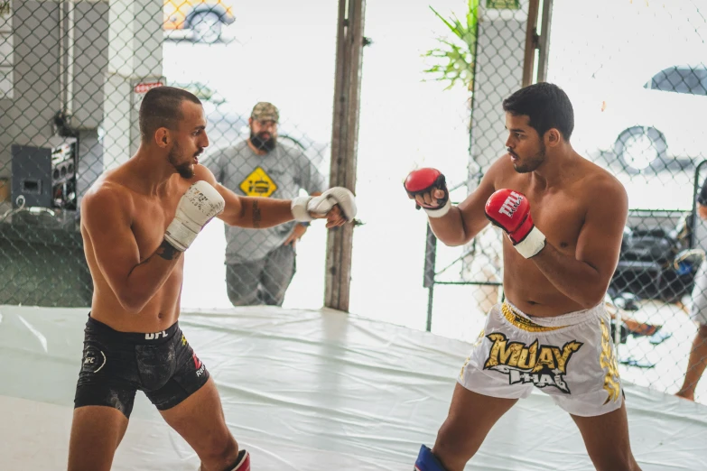 two men in a boxing ring practice punches