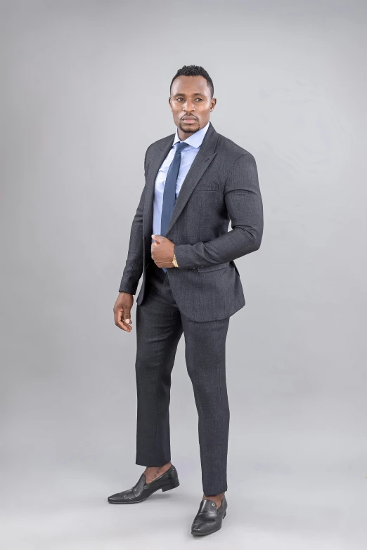 an african american man wearing a suit, white shirt and tie with black shoes